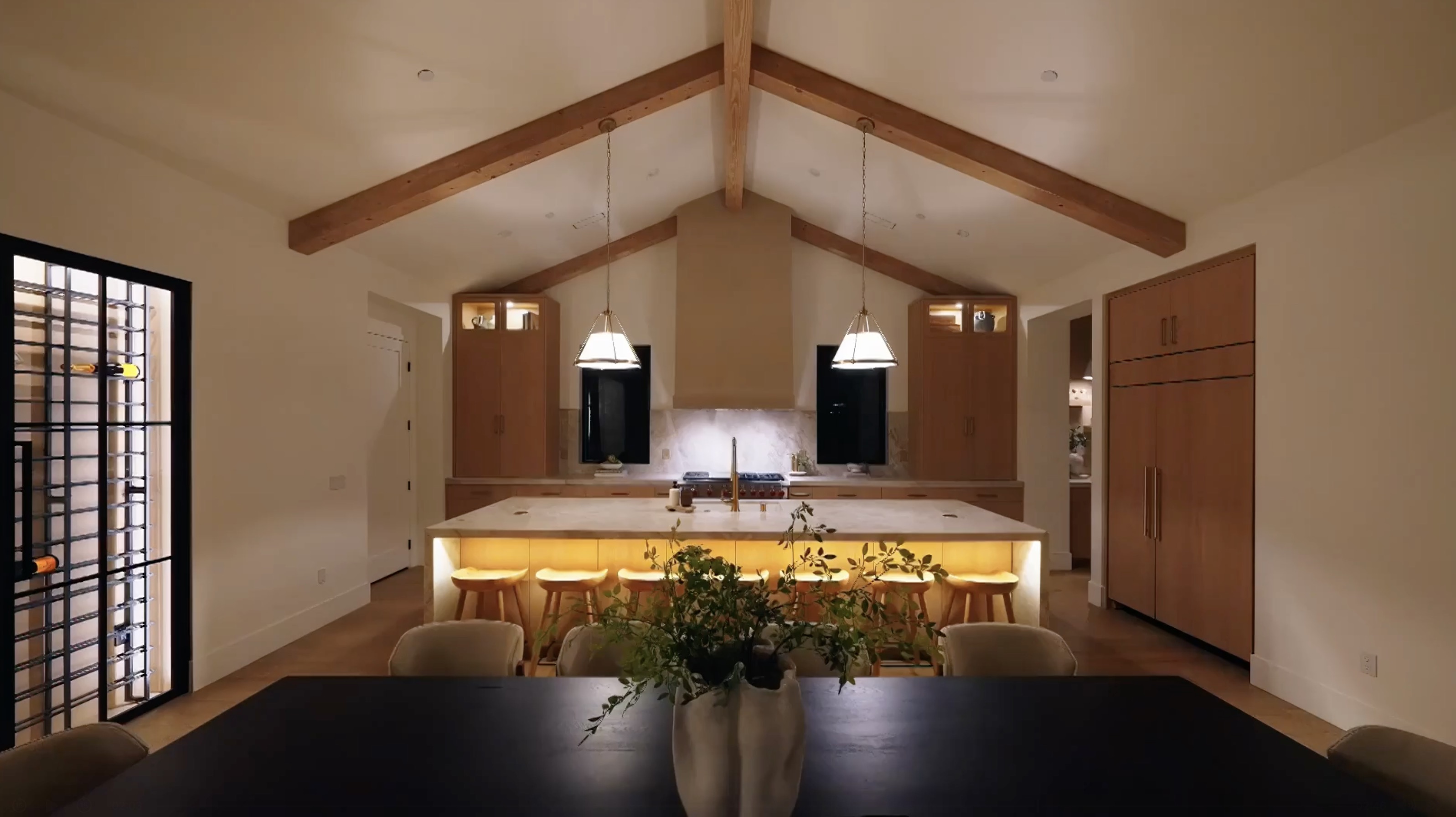 Westminster residence kitchen and dining room with oak cabinetry, stone details, exposed beams, and brass pendants