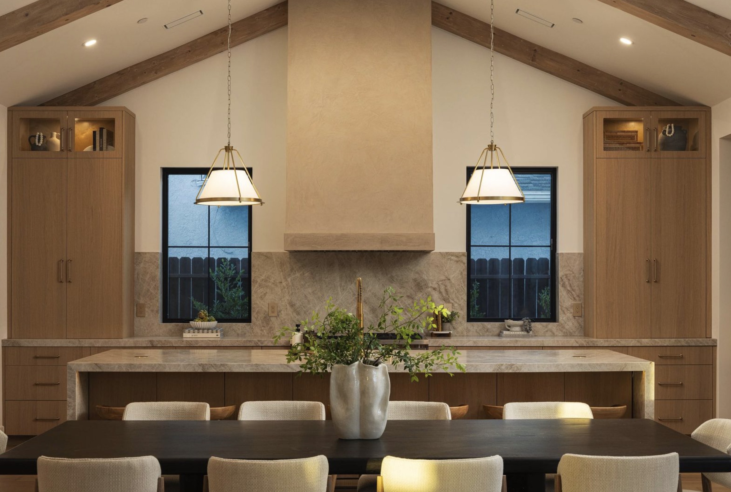 Wide view of the Westminster residence kitchen and dining room with vaulted ceiling and oak millwork