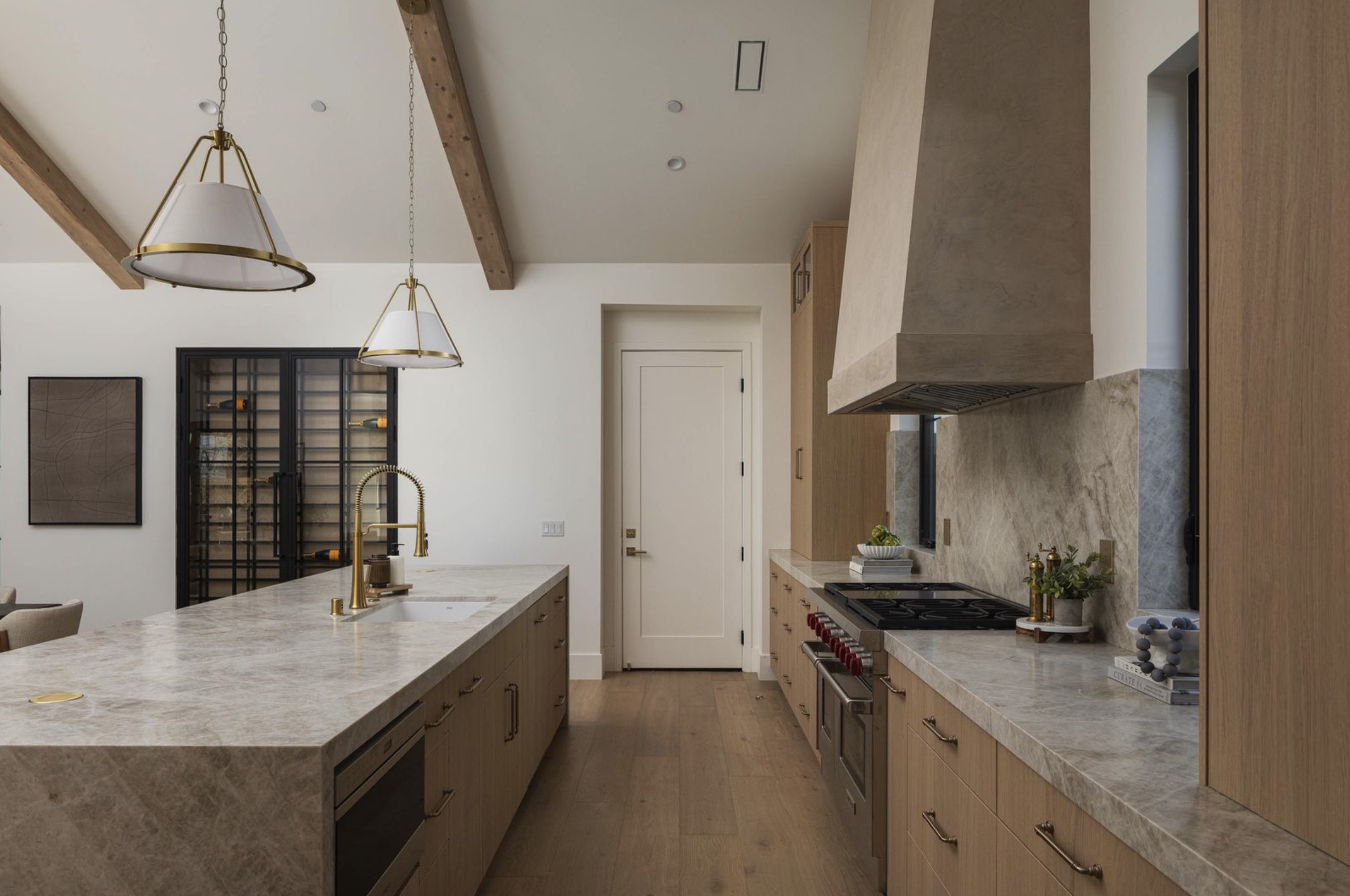 Westminster residence kitchen with oak cabinetry, stone island, exposed beams, and brass lighting